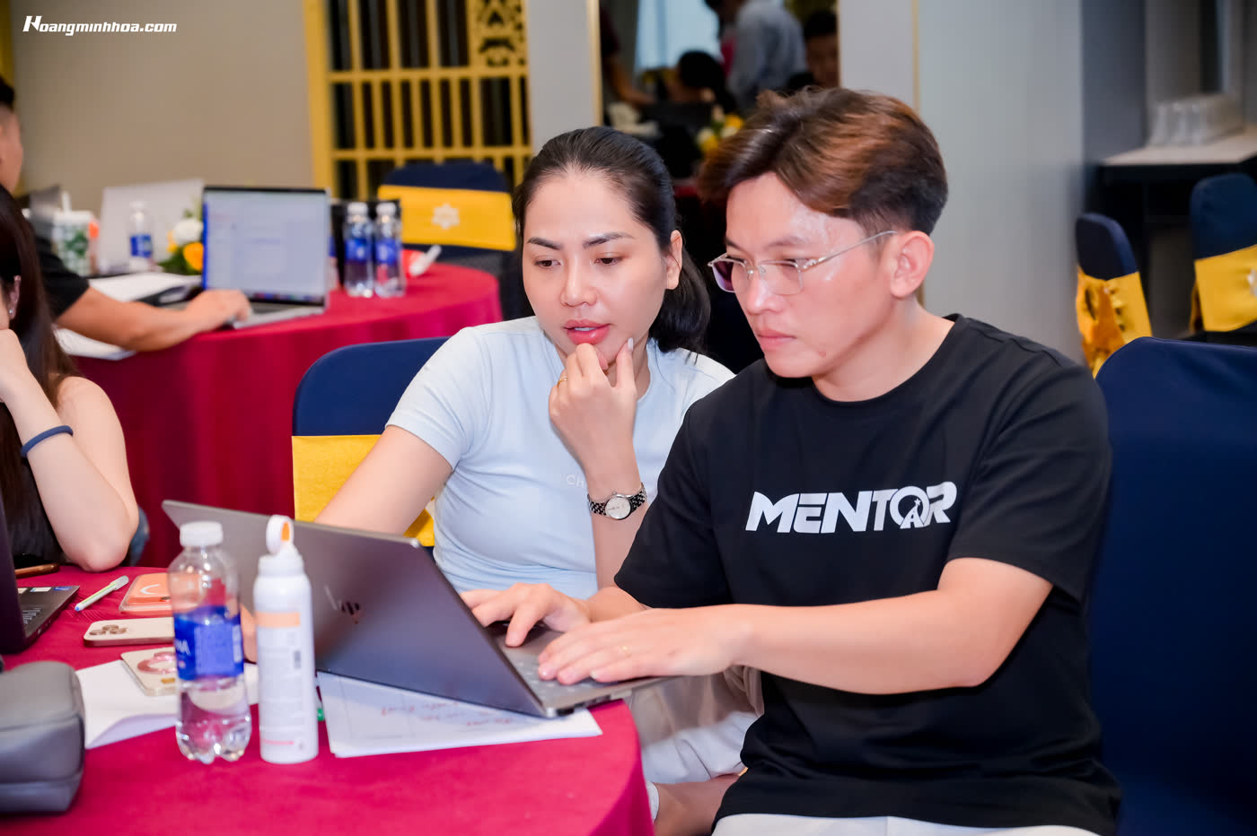 Trợ giảng cầm tay chỉ việc từng học viên trên máy tính